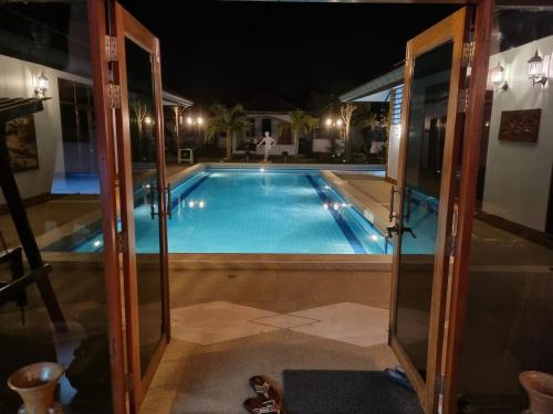 a swimming pool in the middle of a house at night at Meyers Hua Hin in Hua Hin