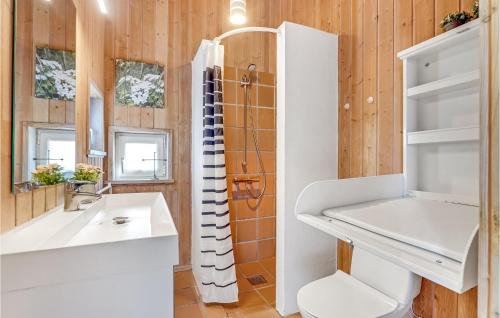 a bathroom with a toilet and a sink and a shower at Nice Home In Hjrring With Sauna, Wifi And Indoor Swimming Pool in Lønstrup