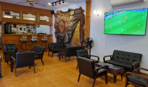 a waiting room with chairs and a tv on the wall at Meyers Hua Hin in Hua Hin