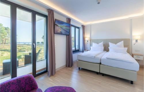 a bedroom with two beds and a couch and windows at Amber in Binz