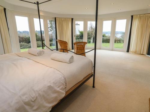 a bedroom with a large bed and windows at Penarvon House in Helford
