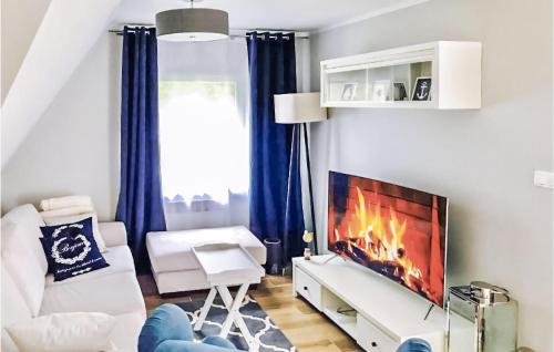 a living room with a tv and a fireplace at 3 Bedroom Lovely Apartment In Lukecin in Łukęcin