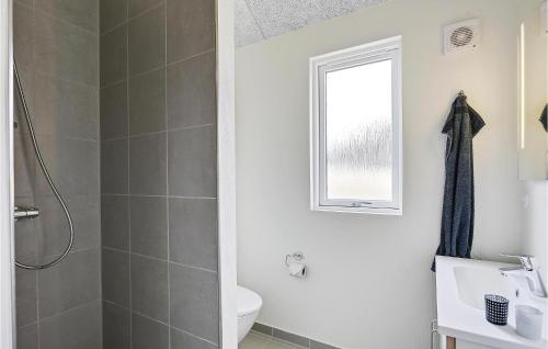 a bathroom with a sink and a toilet and a window at 8 Bedroom Stunning Home In Vejby in Vejby