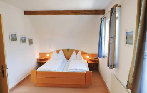 um quarto com uma cama com lençóis brancos e almofadas em Lovely Home In Feistritz Im Rosental With Wifi em Ludmannsdorf