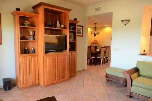 a living room with a television in a wooden entertainment center at Condo Unit 131! Stay with us !!! in French Harbour