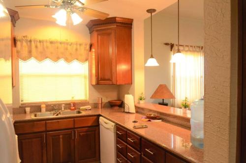 cocina con armarios de madera, fregadero y ventana en Condo Unit for rent! Just a few minutes from LFK!, en French Harbor