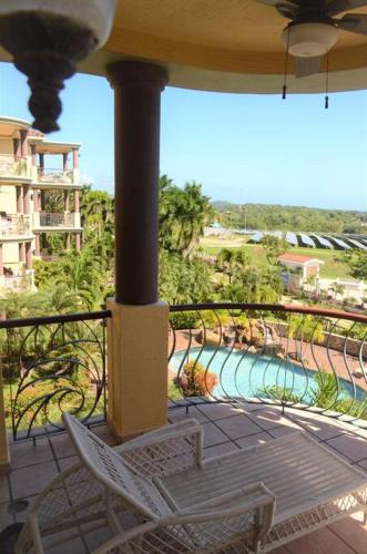 a balcony with a chair and a view of a pool at Condo Unit 131! Stay with us !!! in French Harbour