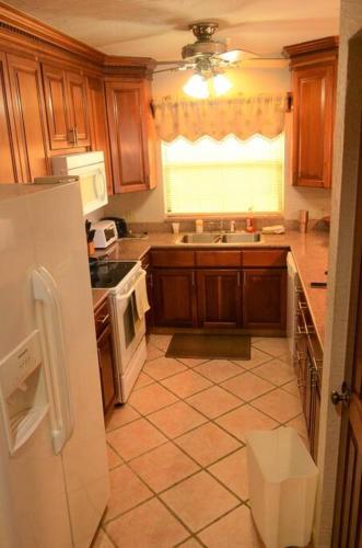 a kitchen with a white refrigerator and a window at Condo Unit 131! Stay with us !!! in French Harbour