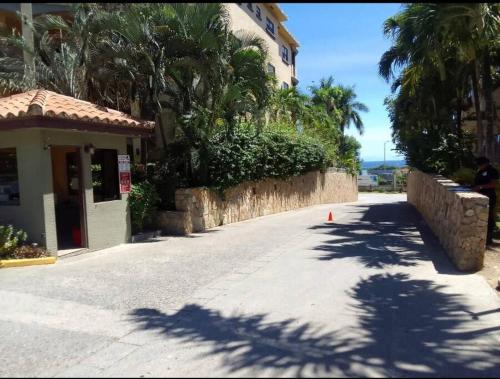 an empty street next to a building with palm trees at Condo Unit 131! Stay with us !!! in French Harbour