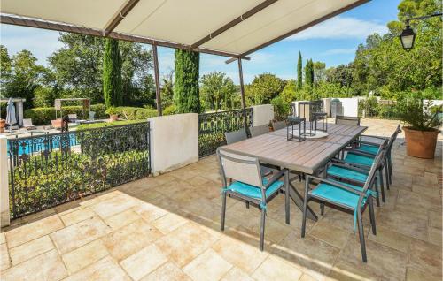 an outdoor patio with a wooden table and chairs at Grand Pavillion in Aubais
