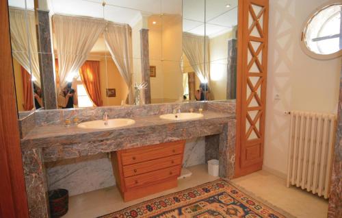 baño con 2 lavabos y espejo grande en Grand Pavillion, en Aubais