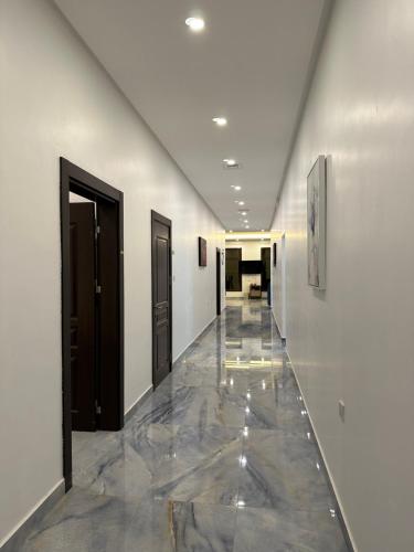 a hallway with two doors and a tile floor at منتجع اووه يامال البحري في الخيران OOh Yaa Mal in Al Khīrān