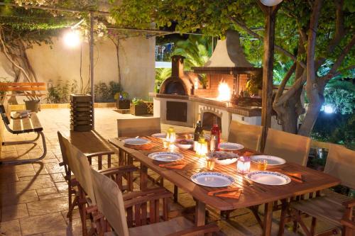 una larga mesa de madera con sillas y chimenea en Iris Apartments en Minia