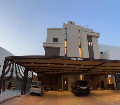 two cars parked in a parking lot in front of a building at منتجع اووه يامال البحري في الخيران OOh Yaa Mal in Al Khīrān