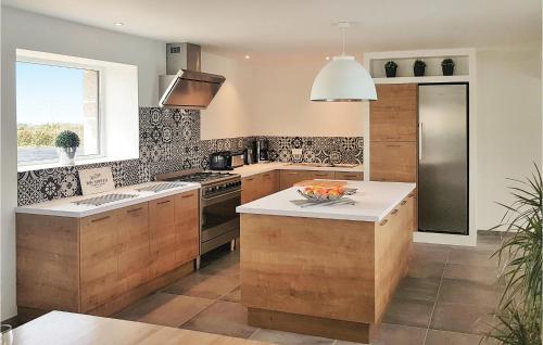 - une cuisine avec des placards en bois et un comptoir dans l'établissement Gorgeous Home In Guisseny With Kitchen, à Guissény