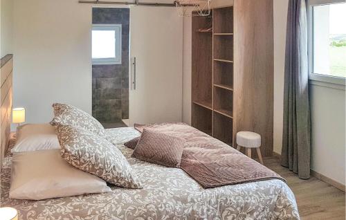sypialnia z łóżkiem z poduszkami w obiekcie Gorgeous Home In Guisseny With Kitchen w mieście Guissény