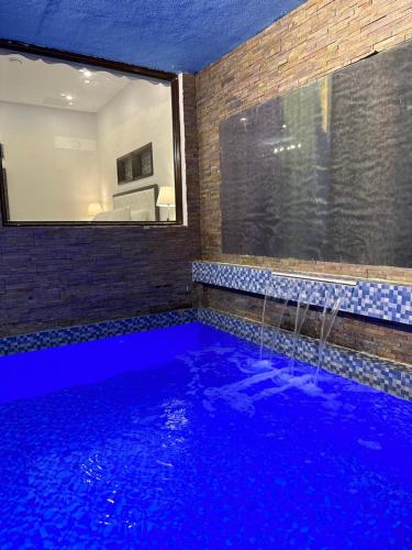 a swimming pool in a room with a mirror at منتجع اووه يامال البحري في الخيران OOh Yaa Mal in Al Khīrān