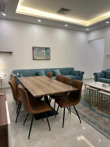 a table and chairs in a room with a couch at منتجع اووه يامال البحري في الخيران OOh Yaa Mal in Al Khīrān