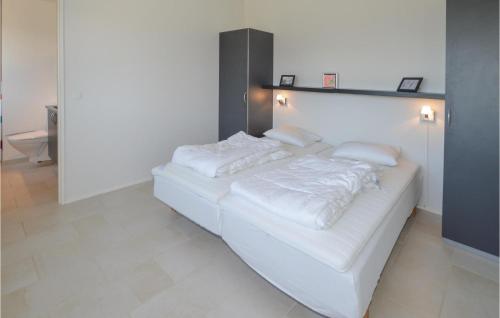 uma cama branca com lençóis brancos e almofadas em Nice Home In Lkken With Kitchen em Lokken