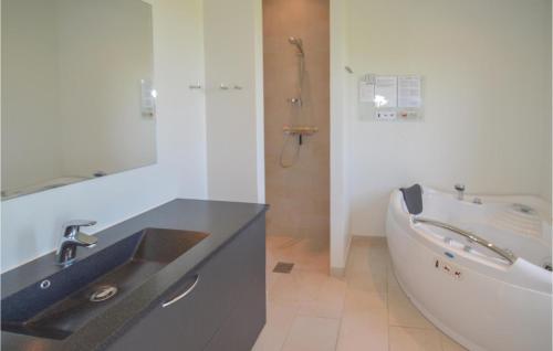 uma casa de banho com um lavatório e uma banheira em Nice Home In Lkken With Kitchen em Lokken