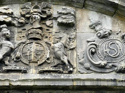 a building with a stone wall with a clock on it at Craigiehall Temple in Edinburgh