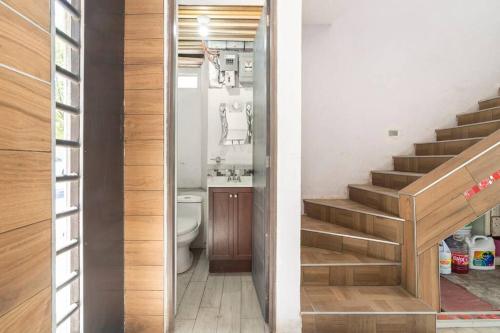 a bathroom with a toilet and a staircase in a house at Habitación Lui confortable moderna con baño privado in Mexico City