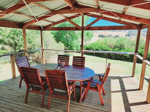 a wooden table and chairs on a deck at Yaringa Cottage, ultimate entertainer! in Encounter Bay