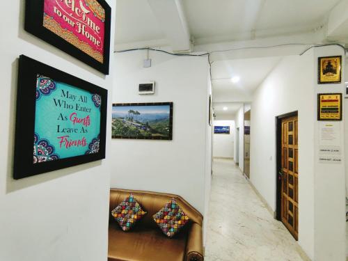 un pasillo con sofá y un cartel en la pared en Jain Homestay, en Darjeeling