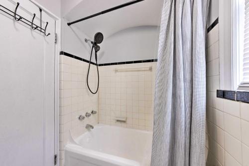 ein weißes Bad mit einem Duschvorhang und einer Badewanne in der Unterkunft St Louis Vacation Rental 4 Mi to Airport! in Woodson Terrace