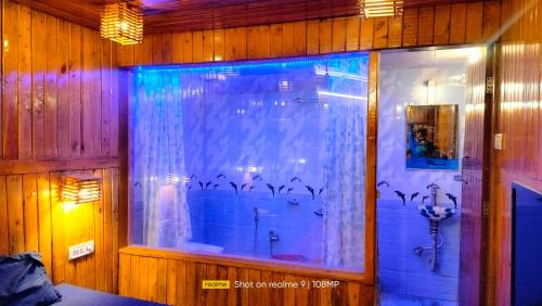 a bathroom with a shower and a window with a curtain at altafs motel in Matheran
