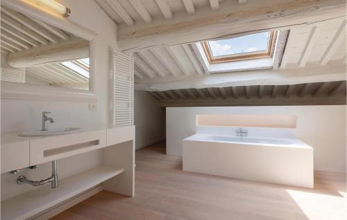La salle de bains est pourvue d'un lavabo blanc et d'une lucarne. dans l'établissement Villa Ploner, à Lari