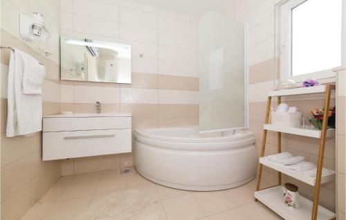 a white bathroom with a toilet and a sink at Stunning Home In Radosic With Wifi, Outdoor Swimming Pool And Heated Swimming Pool in Radošić