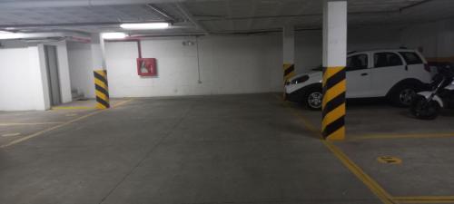 a parking garage with two cars parked in it at Departamento excelente ubicación con parqueo in Cuenca