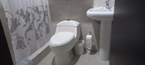a bathroom with a toilet and a sink at Departamento excelente ubicación con parqueo in Cuenca