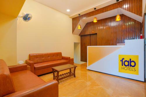 een woonkamer met een bank en een groot scherm bij FabExpress Colaba Grand in Mumbai