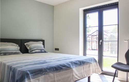 een slaapkamer met een bed en een groot raam bij Cozy Home In Diksmuide With Outdoor Swimming Pool in Diksmuide