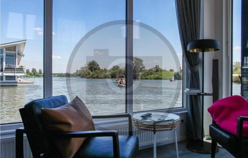 a room with a large window with a view of a river at Houseboat Waterlelie in Ohé en Laak