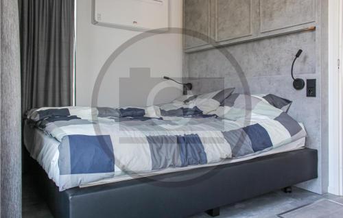 a bed with a blue and white comforter in a room at Houseboat Waterlelie in Ohé en Laak