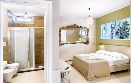 a bedroom with a bed and a toilet and a mirror at Cozy Home In Ragusa With Outdoor Swimming Pool in Ragusa