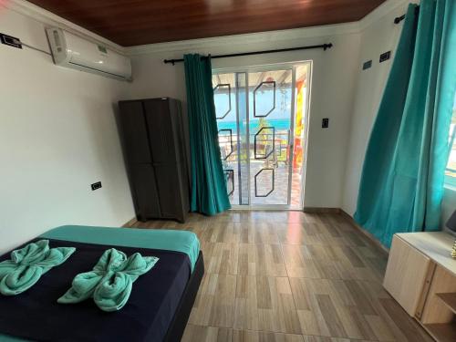 a bedroom with a bed and a sliding glass door at Posada Ashanty in Providencia