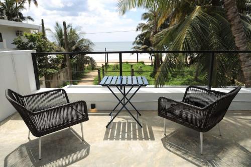 two chairs and a table on a balcony with the ocean at Yachtman's House- Matara Fort in Matara