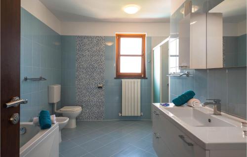 a blue bathroom with a sink and a toilet at Awesome Home In Hr-52215 Vodnjan With House Sea View in Vodnjan
