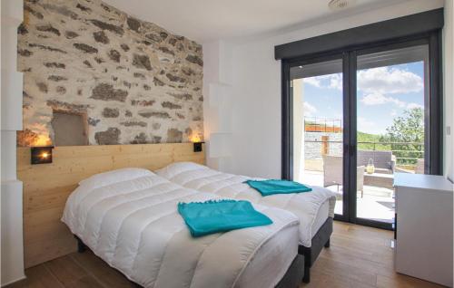 2 camas en un dormitorio con pared de piedra en Gorgeous Home In Alissas With Kitchen en Alissas