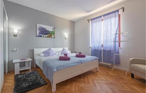 ein Schlafzimmer mit einem Bett mit lila Kissen darauf in der Unterkunft Stunning Home In Bale With 4 Bedrooms, Wifi And Outdoor Swimming Pool in Bale