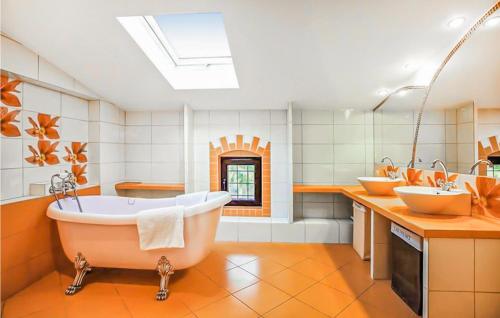 een badkamer met 2 wastafels en een groot bad bij Cozy Home In Sasino With Kitchen in Sasino