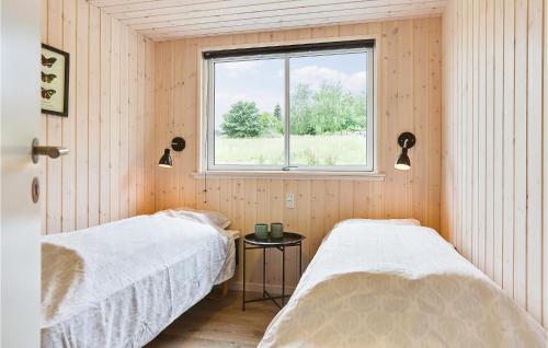a bedroom with two beds and a window at Cozy Home In Vejby With Indoor Swimming Pool in Vejby