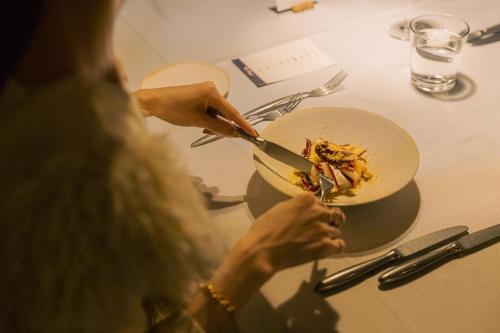a woman sitting at a table with a bowl of food at WEAZER 西伊豆 in Izu