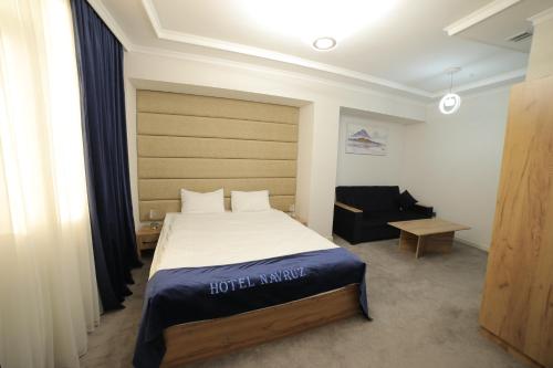 ウルゲンチにあるHOTEL NAVRUZのベッドと椅子付きのホテルルーム