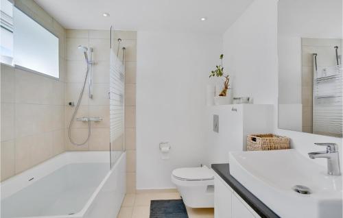 a white bathroom with a tub and a toilet and a sink at Stunning Home In Kalvehave With 4 Bedrooms And Wifi in Kalvehave