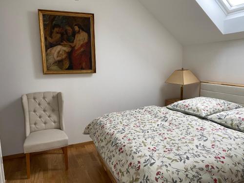een slaapkamer met een bed en een stoel en een schilderij bij Haus Mathilda in Papstdorf